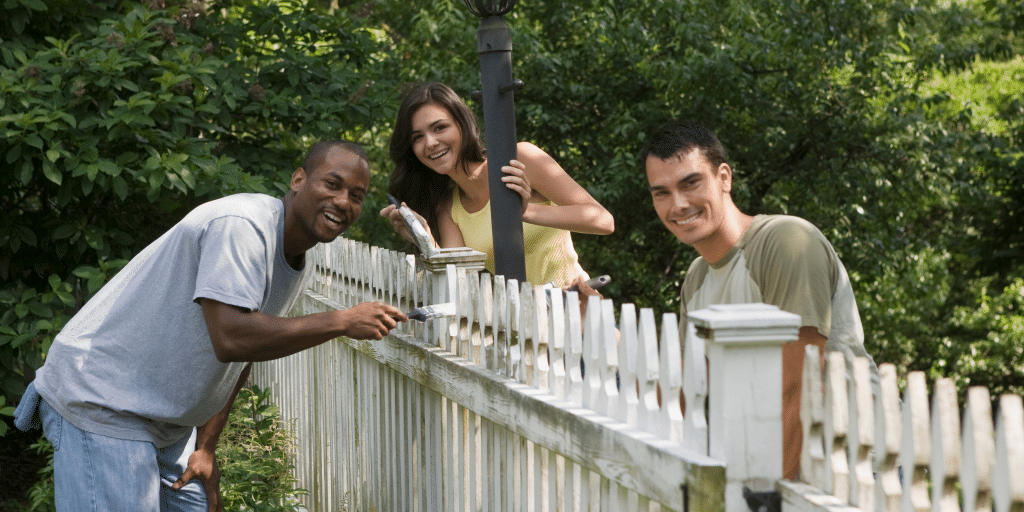 college students painting fence