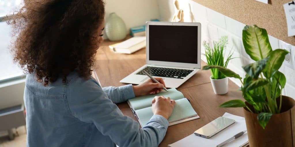 student writing and working at computer