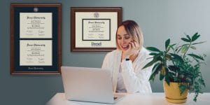 woman in office with Drexel University degree frames on wall