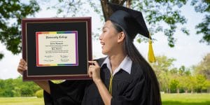 Grad looking at her rainbow pride diploma frame