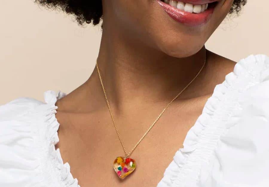 closeup of floral pride heart necklace on woman