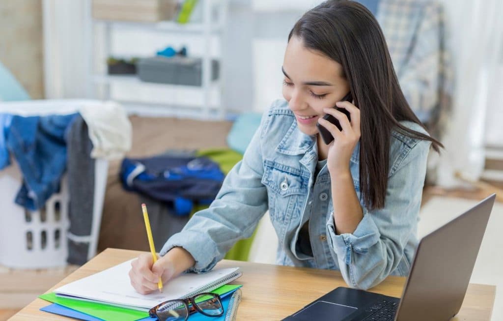 girl on phone taking notes