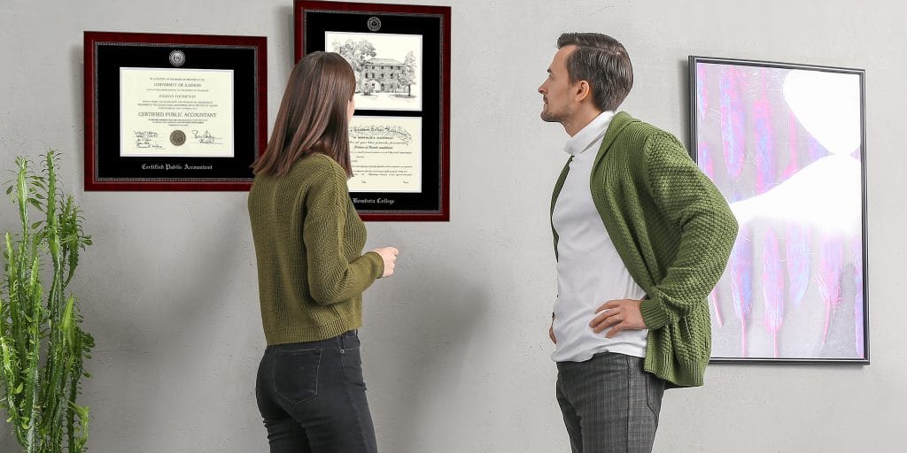 man and woman admiring campus scene diploma frame