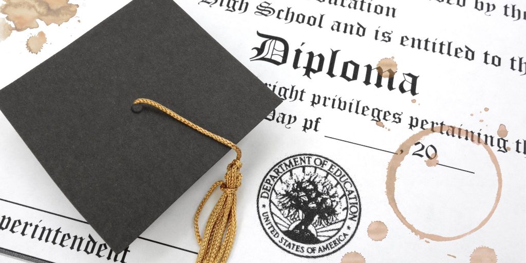 grad cap sitting on stained diploma