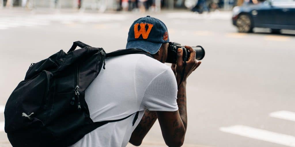 student in W cap taking photo