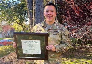 army man holding diploma frame