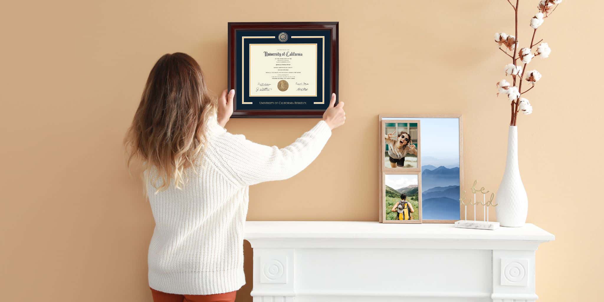 woman hanging frame above mantle