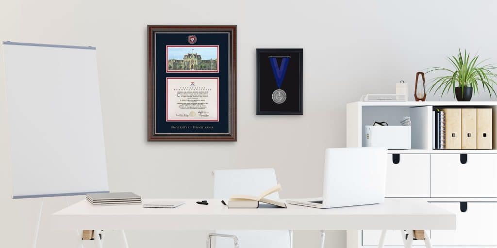UPenn campus scene frame and medallion frame on wall in white office