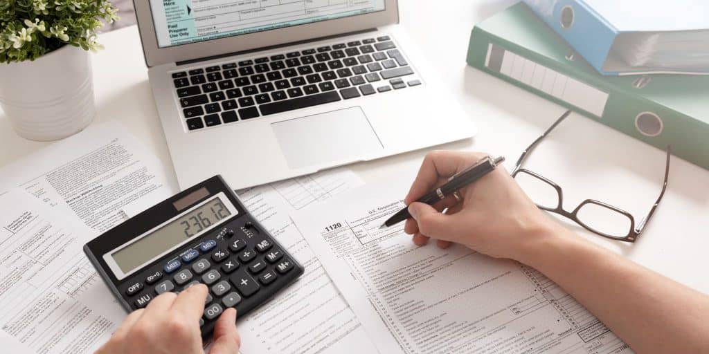 calculator computer and tax papers on desk