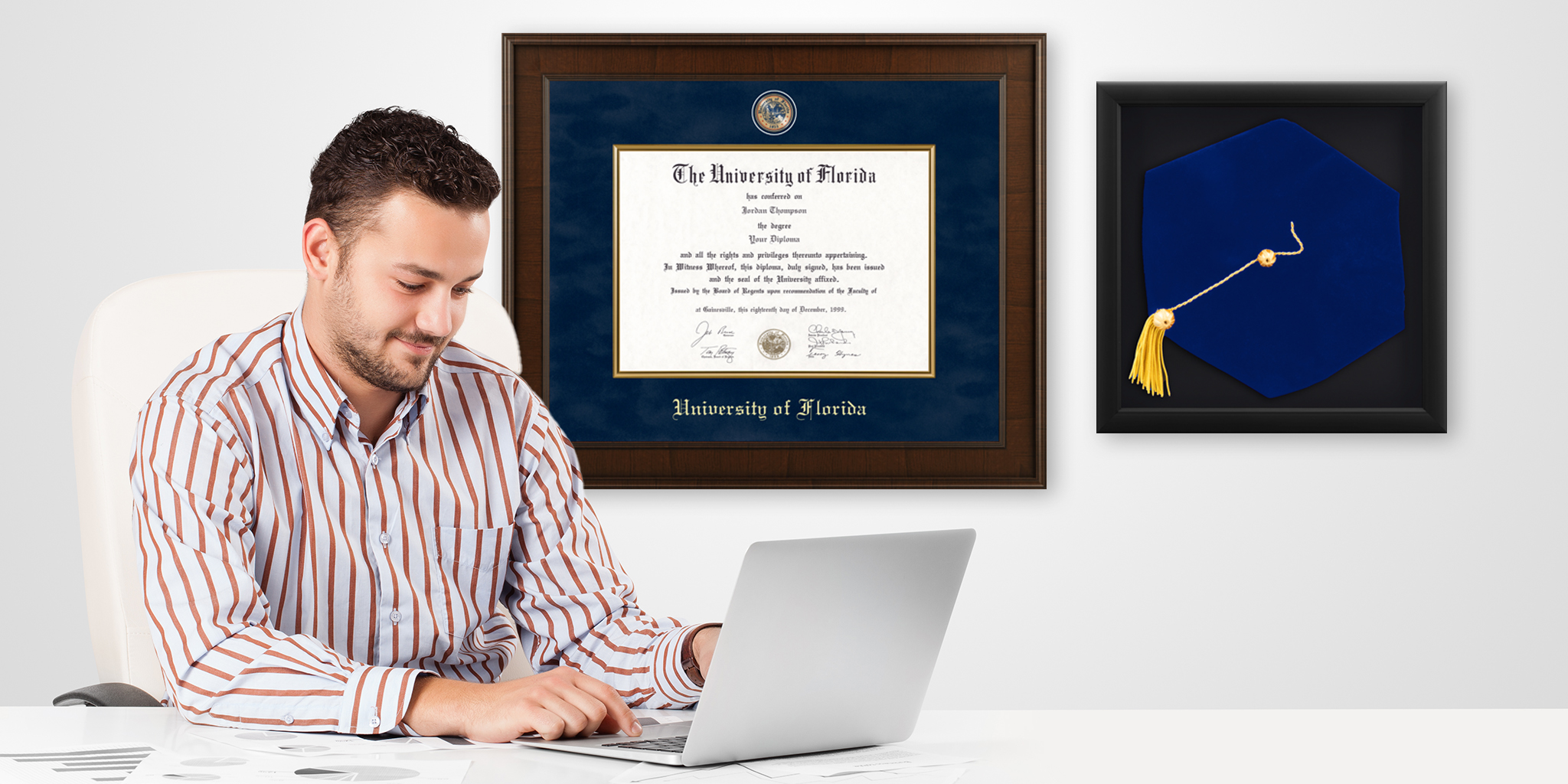 businessman working on computer with presidential diploma frame and doctoral tam shadow box hung on wall behind him in office