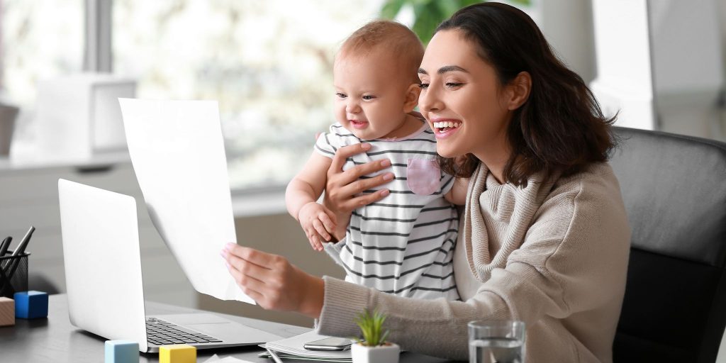 smiling mom with baby at desk in office