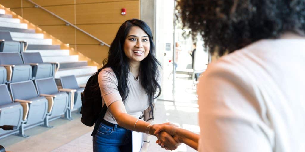 student shaking hand of professor