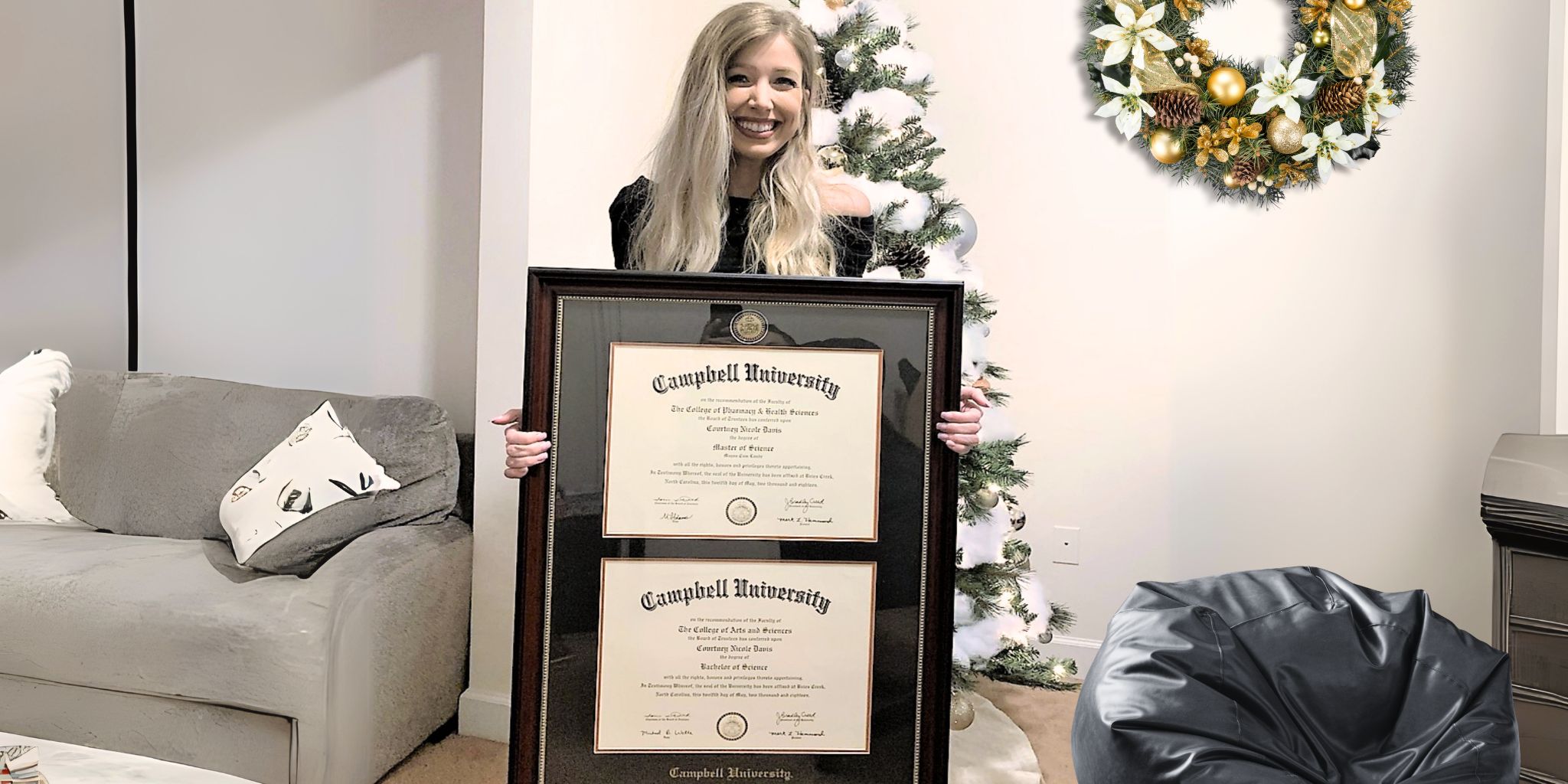 Woman on Xmas holding Cambell University double degree frame