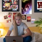 teen on laptop in room with varsity letter frame and shadowbox on wall