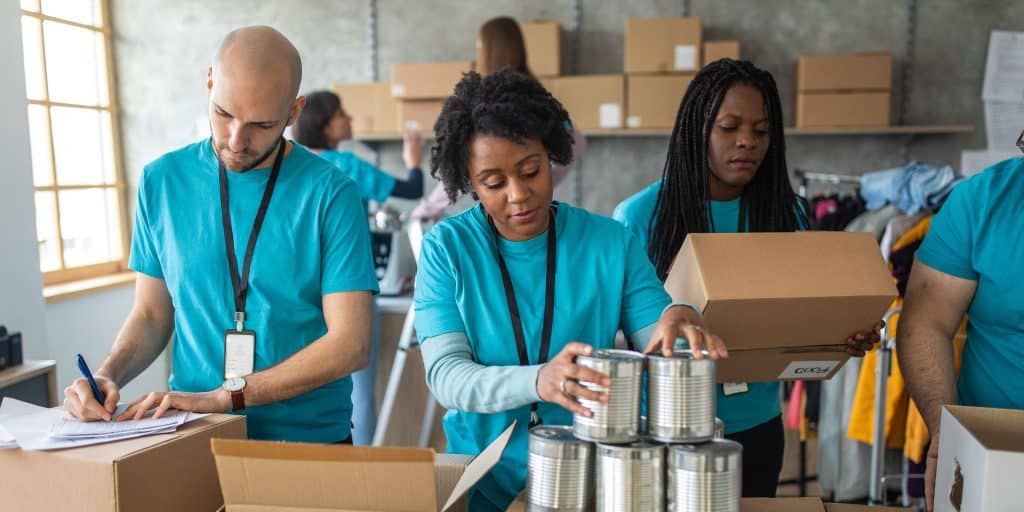 three people volunteering at food drive