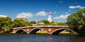 view of harvard university across river and bridge