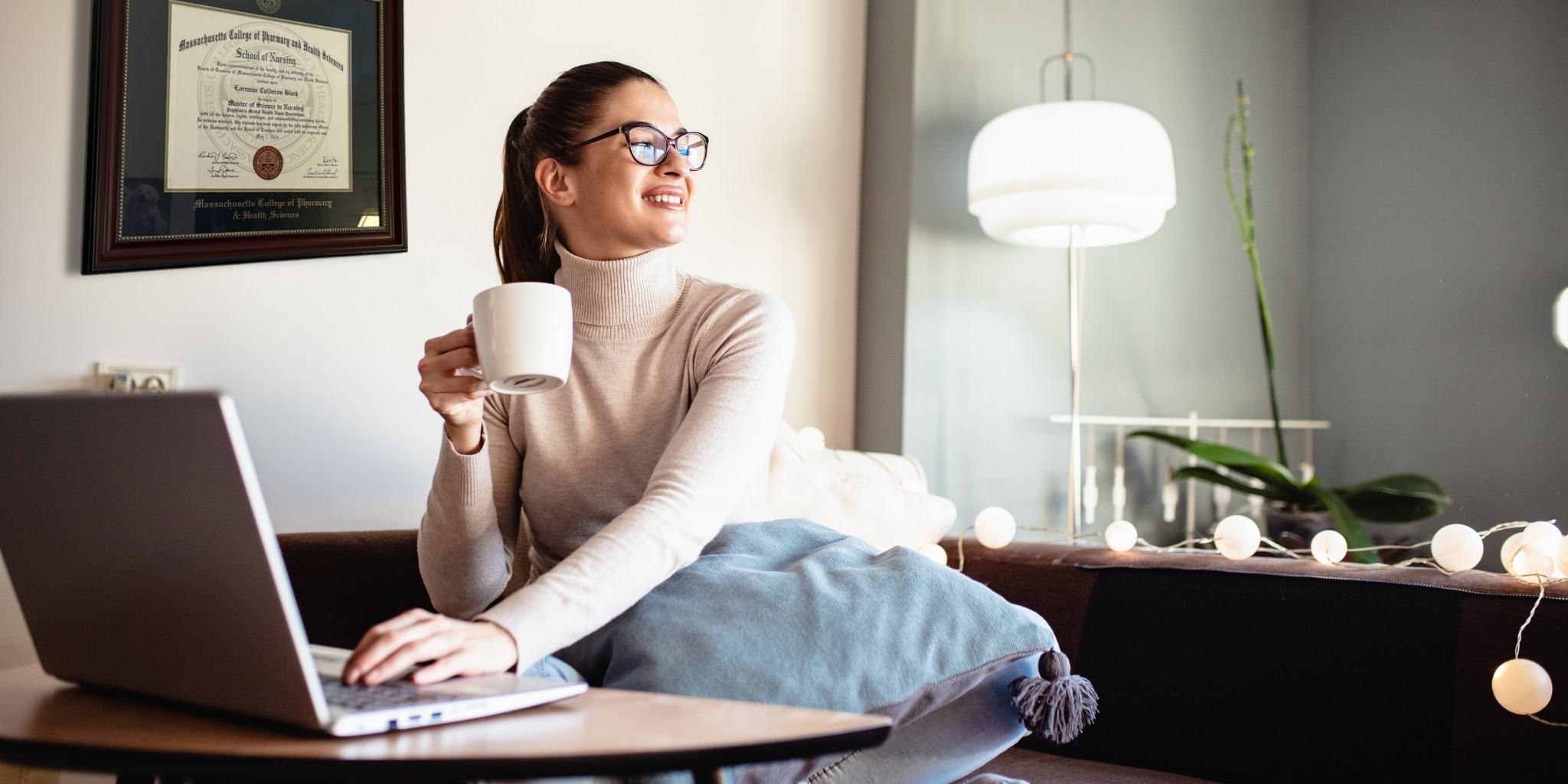 smiling woman with coffee cup at computer