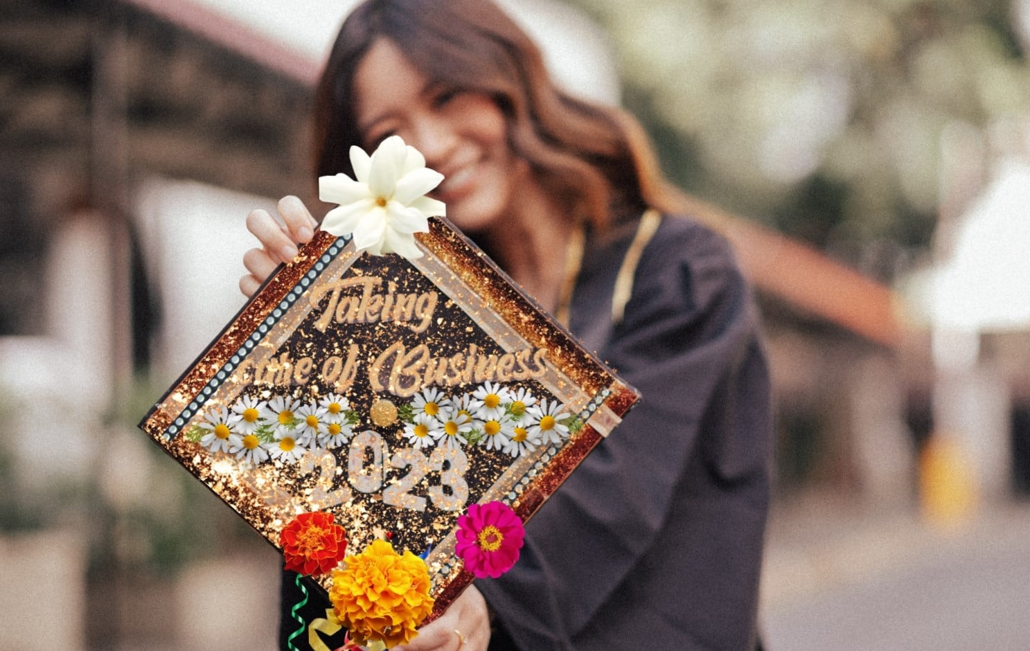 graduate holding floral decorated grad cap