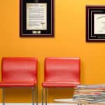 waiting room with framed medical degrees and hippocratic oath frame on wall