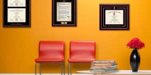 waiting room with framed medical degrees and hippocratic oath frame on wall