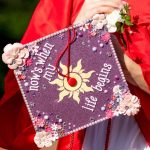 graduate holding decorated graduation cap