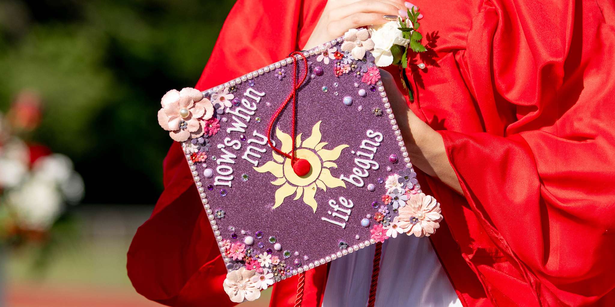 graduate holding decorated graduation cap