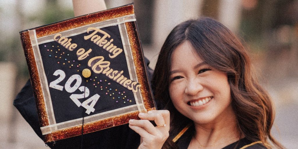 graduatessmiling and posing with decorated grad cap