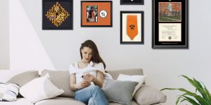 woman on couch with princeton graduation frames on wall above her