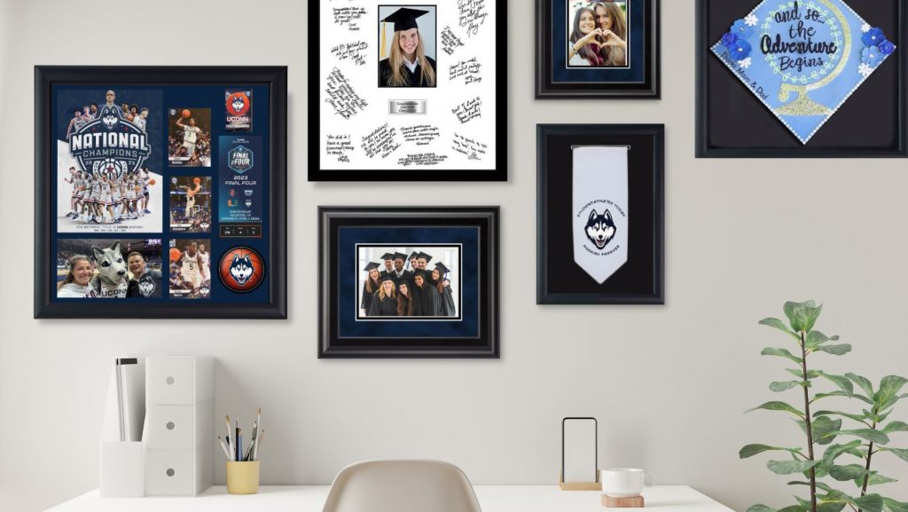 uconn graduation frames above desk on wall