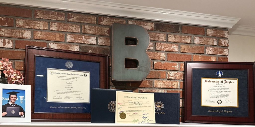 custom diploma frames and photo frames on living room mantle place