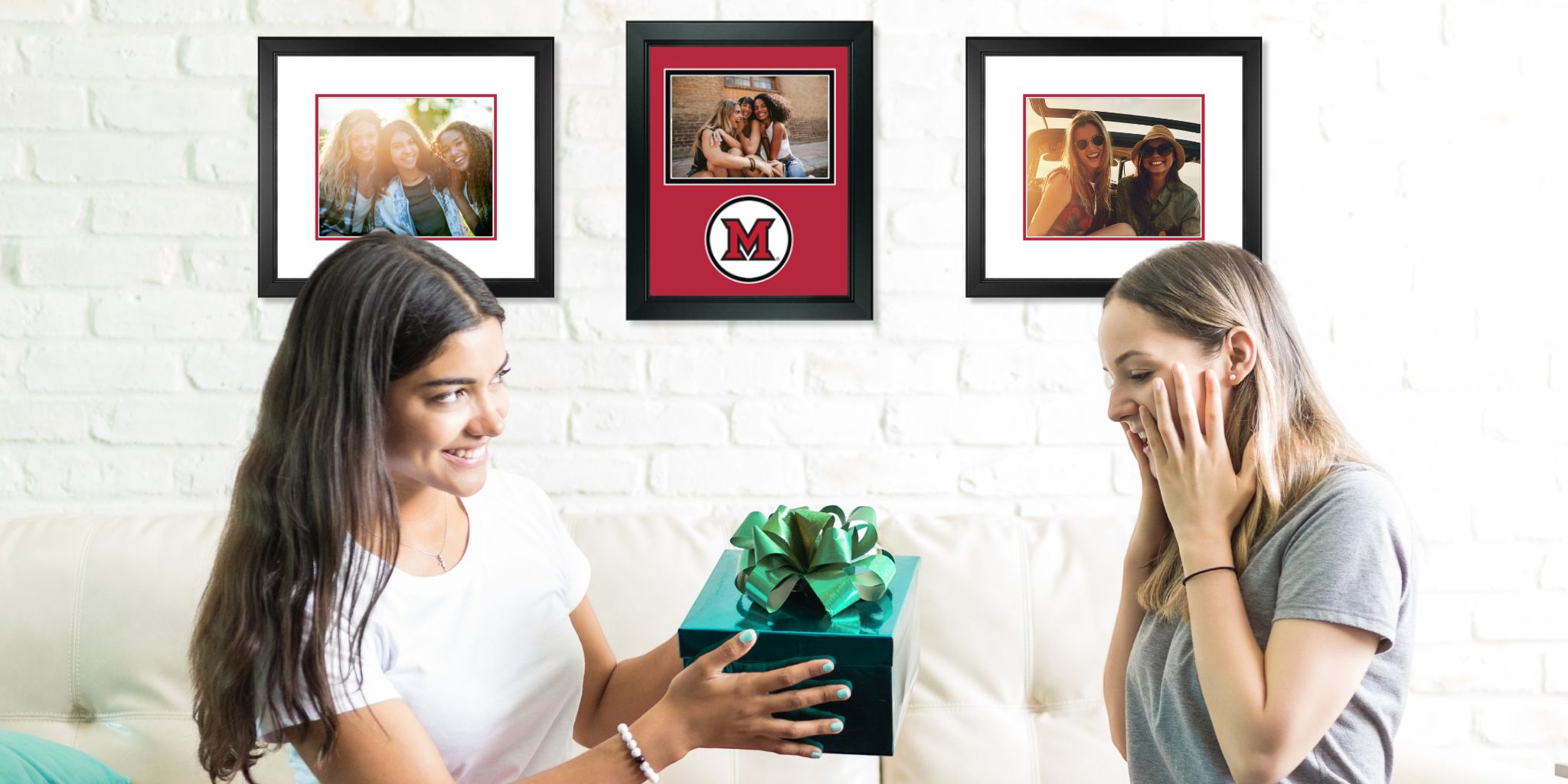 brunette teen handing gift with green bow to surprised blonde roommate