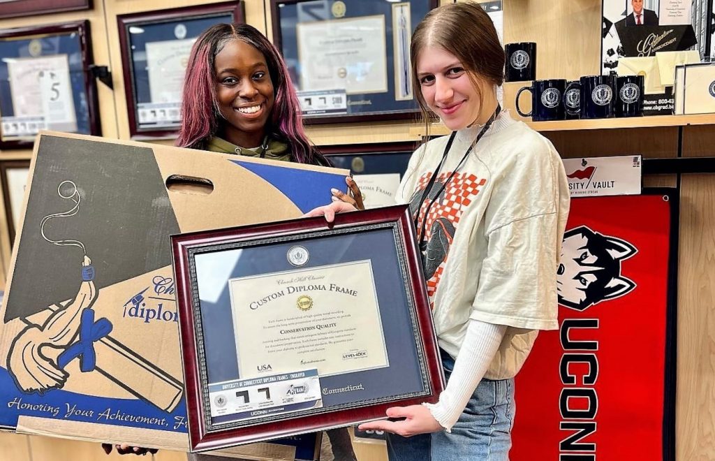 girls at uconn bookstore with diploma frame and box