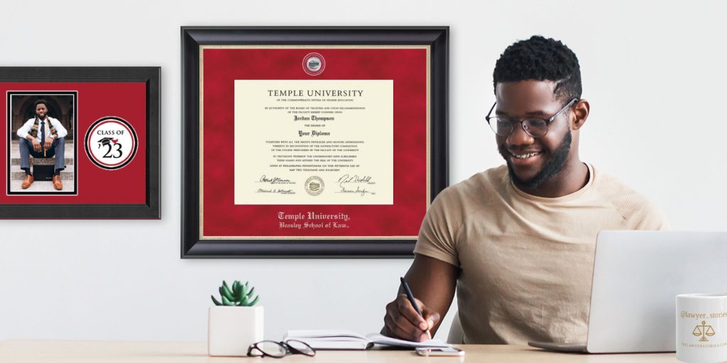 man at desk with temple law degree behind him