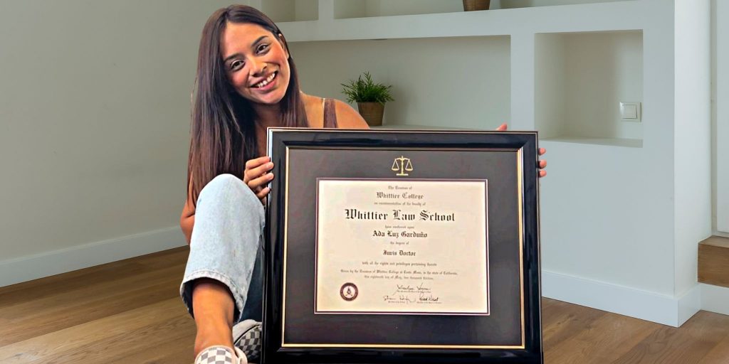 young lawyer holding her whittier law school diploma frame