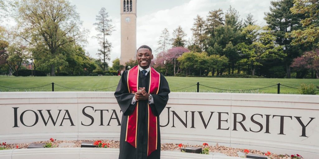 iowa state graduate in regalia standing on campus