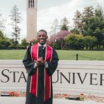 iowa state graduate in regalia standing on campus