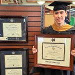 Notre Dame grad in bookstore holding ND diploma frame