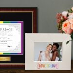 LGBTQ marriage certificate frame next to a Love Is Love photo frame on table