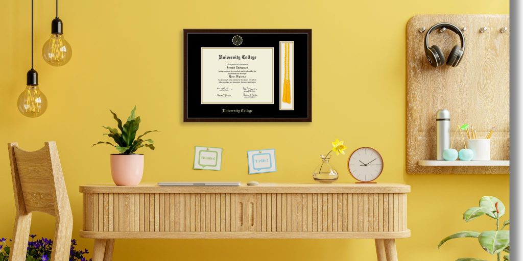 tassel and cord diploma frame on yellow wall behind desk