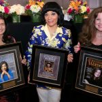 three women holding custom award frames