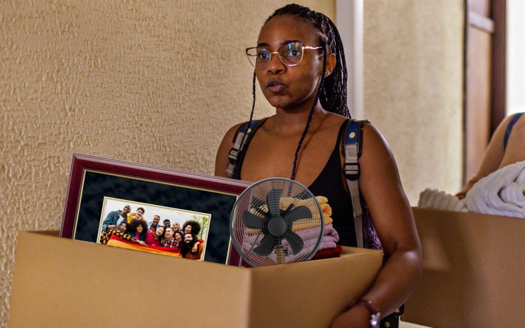 nervous college student carrying box into dorm