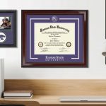 Kansas State University diploma frame and photo frame hanging above desk in office