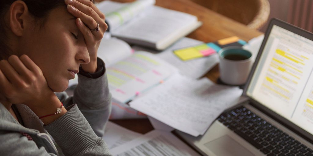 Stressed-out student at computer cupping head due to student burnout