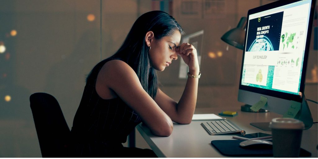 Woman at desk with headache due to stress