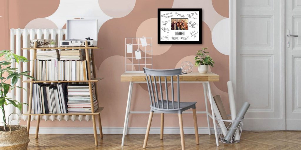 dorm room with desk and shelving with pink wallpaper on wall and church hill classics autograph frame