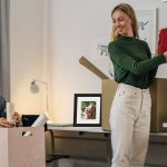 two girls in a dorm room decorating walls with a custom photo frame on desk