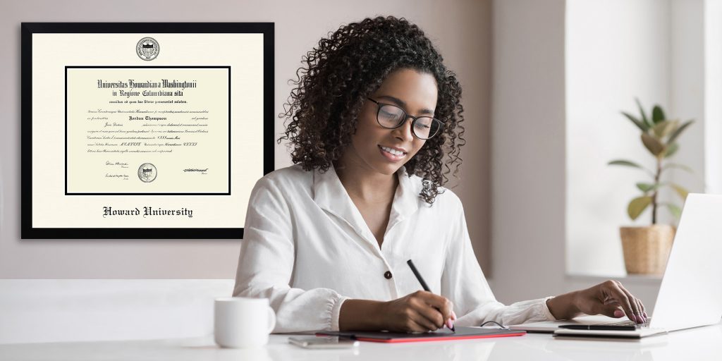 Woman working at an office desk with custom Howard University frame on the wall behind her