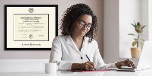 Woman working at an office desk with custom Howard University frame on the wall behind her