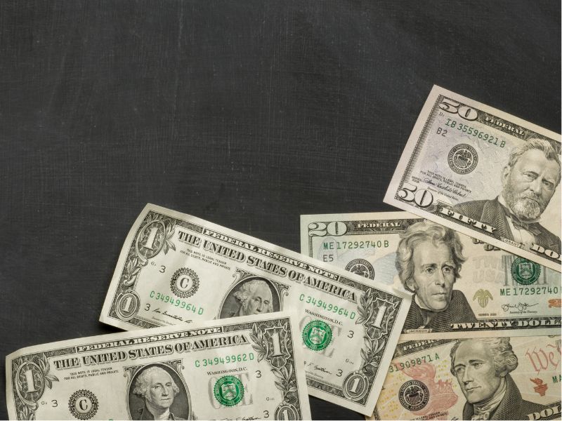 stack of various dollar bills on a black background