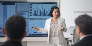 Woman in front of screen conducting a multimedia presentation